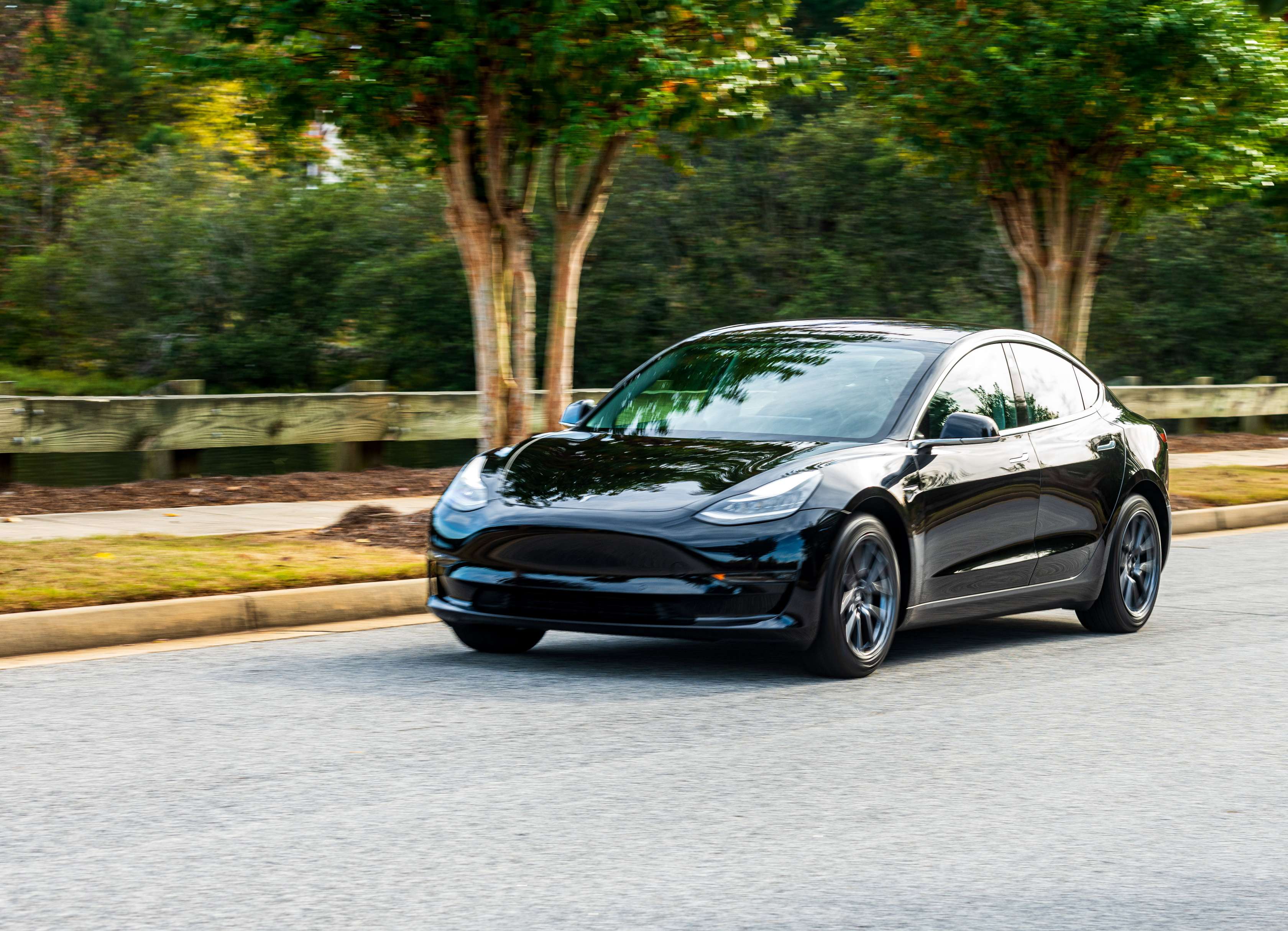 Elektroauto Reichweite: Schwarzes Tesla E-Auto fährt auf einer Straße