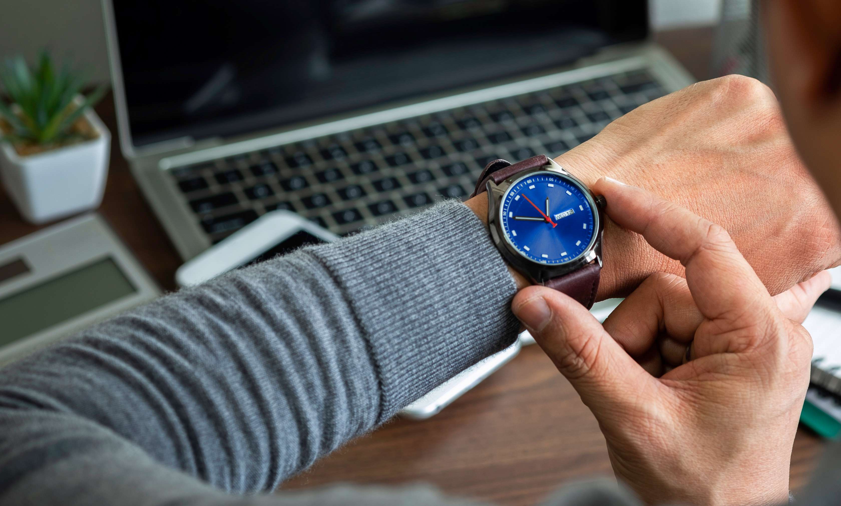 Uhrenversicherung: Ein Mann hebt seine Arbanduhr am Handgelenk an
